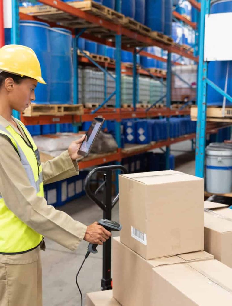 Female worker scanning package with barcode scanner while using